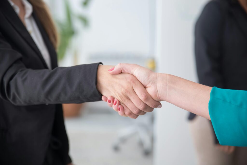 pexels photo 8171174 8171174 Close-up of a professional handshake between businesswomen in an office environment.